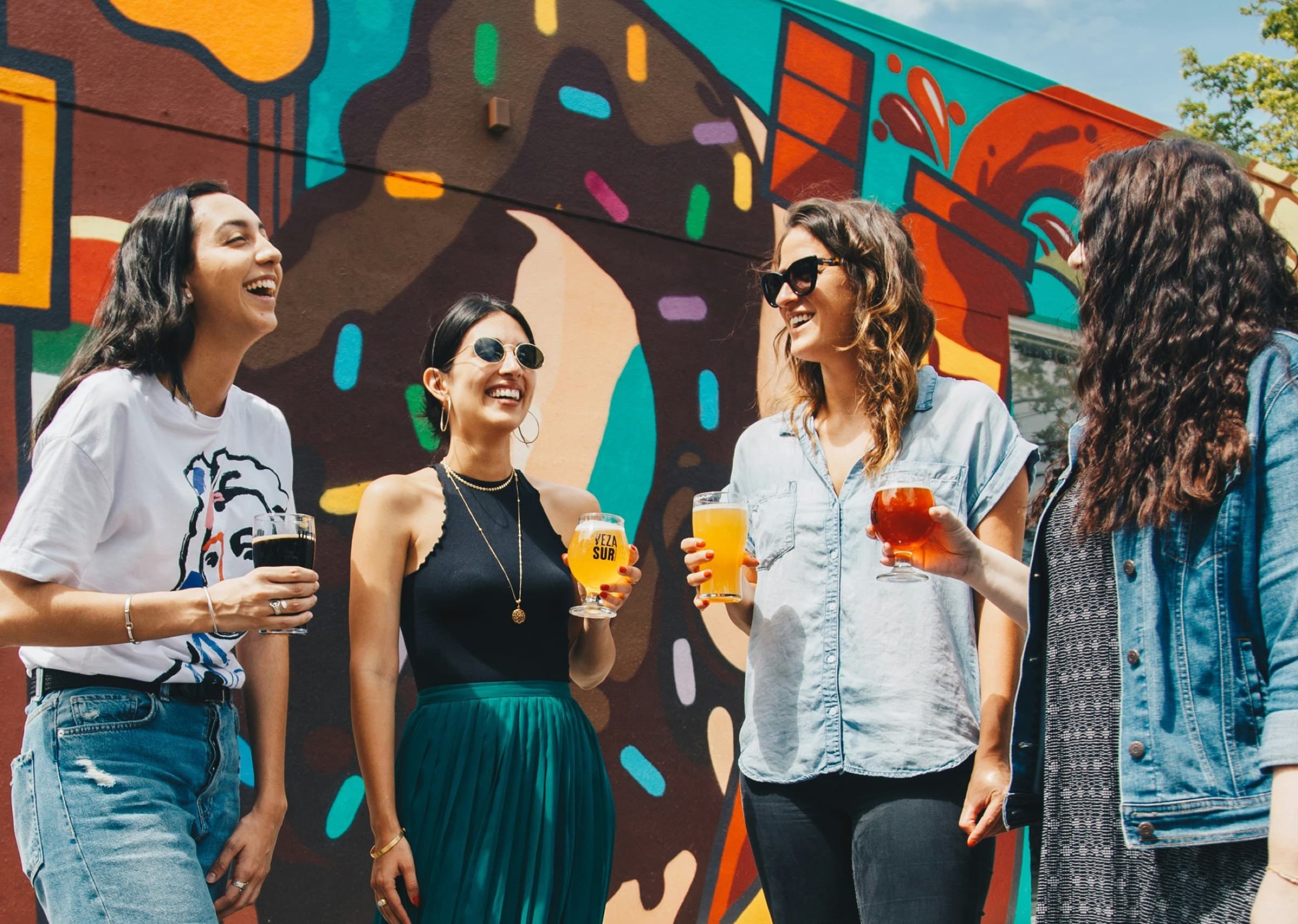 Friends in front of a painted city mural